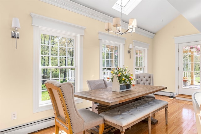 dining space with vaulted ceiling, light hardwood / wood-style floors, an inviting chandelier, and a baseboard heating unit