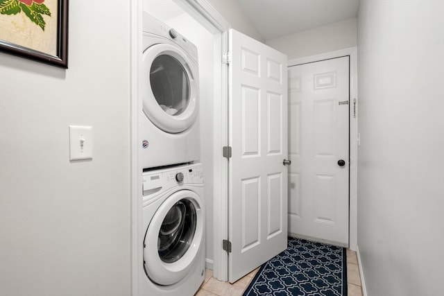 laundry room featuring light tile patterned floors and stacked washer / drying machine