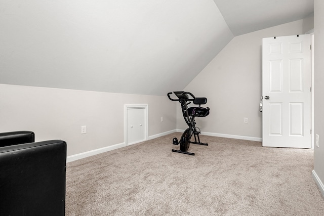 workout room with lofted ceiling and light carpet