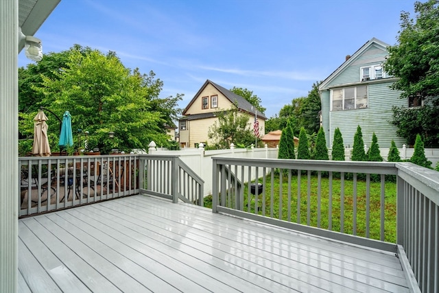 wooden deck featuring a lawn