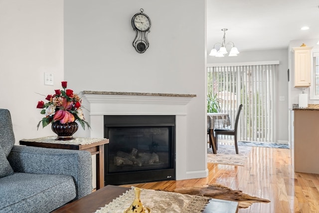 living room featuring light wood-type flooring and a notable chandelier