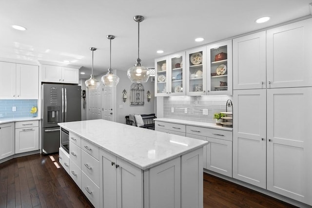 kitchen with stainless steel fridge, decorative backsplash, white cabinetry, and recessed lighting