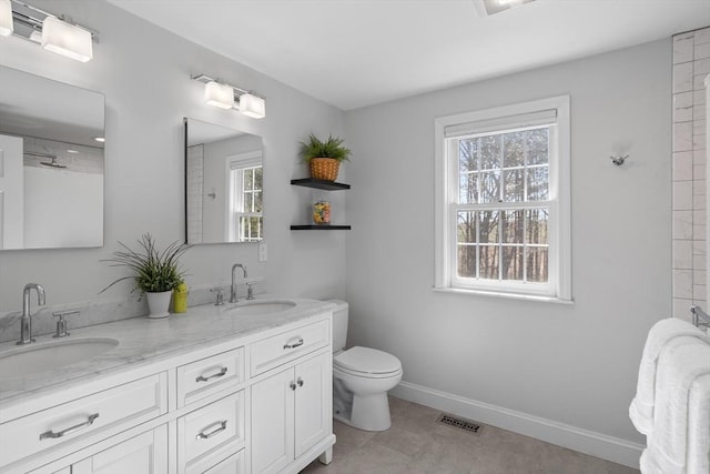 bathroom featuring double vanity, baseboards, visible vents, and a sink