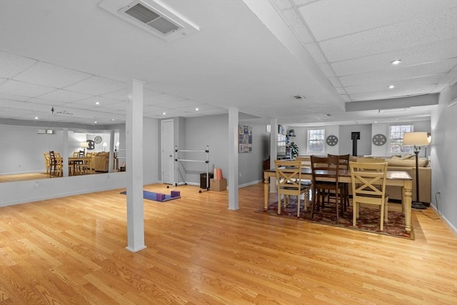 dining area featuring a paneled ceiling, baseboards, visible vents, and light wood-style flooring