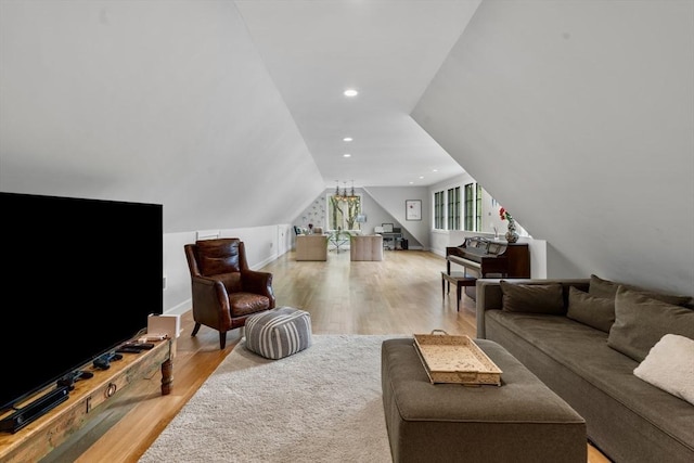 living room featuring baseboards, vaulted ceiling, and wood finished floors