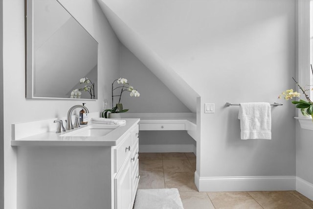 bathroom with vanity, baseboards, and lofted ceiling