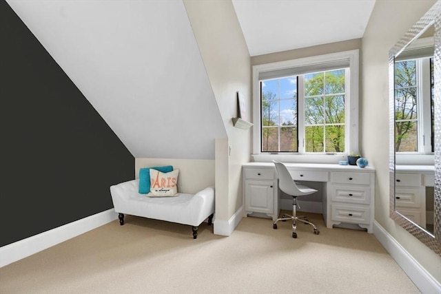 office space featuring baseboards, light carpet, and vaulted ceiling