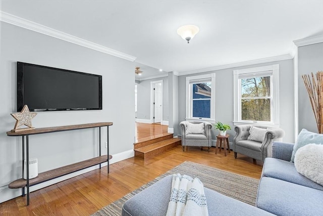 living area with crown molding, baseboards, wood finished floors, and baseboard heating