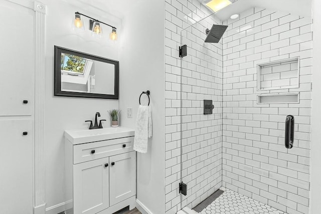 full bath featuring vanity, baseboards, and a stall shower