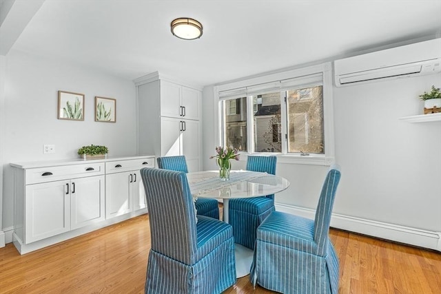 dining space featuring an AC wall unit, baseboards, a baseboard heating unit, and light wood-type flooring
