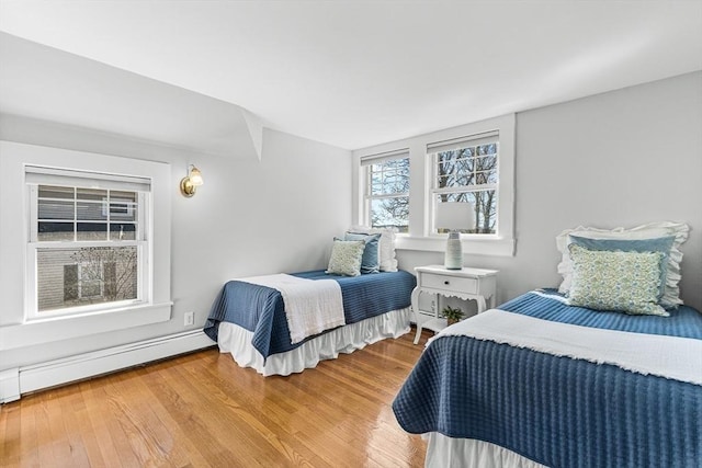 bedroom featuring a baseboard radiator and wood finished floors