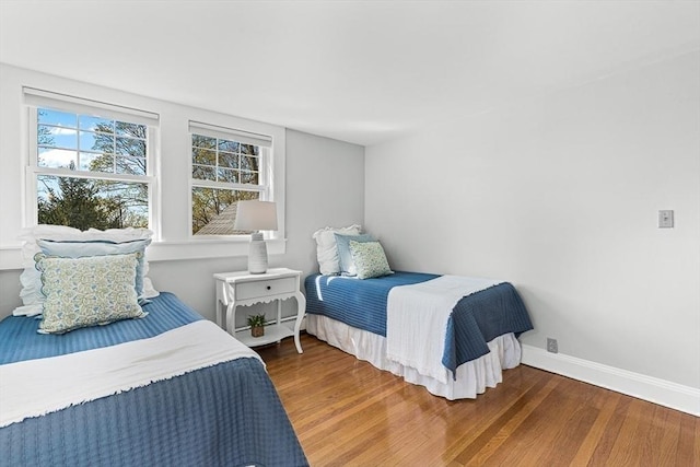 bedroom with baseboards and wood finished floors