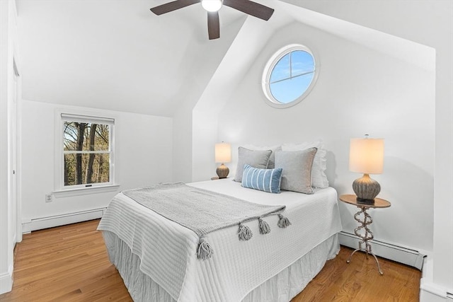 bedroom featuring multiple windows, baseboard heating, and lofted ceiling