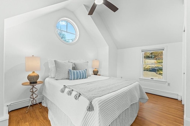 bedroom with a baseboard radiator, vaulted ceiling, a baseboard heating unit, and multiple windows