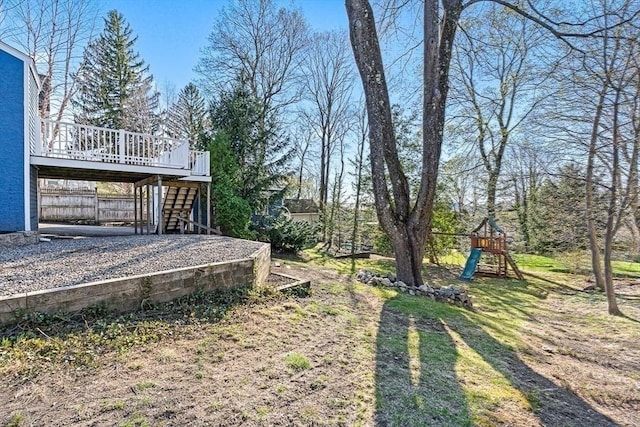 view of yard featuring a playground, a deck, and stairway