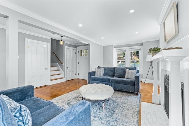 living room with recessed lighting, a fireplace with flush hearth, wood finished floors, and stairway