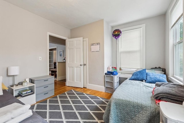 bedroom with baseboards and wood finished floors