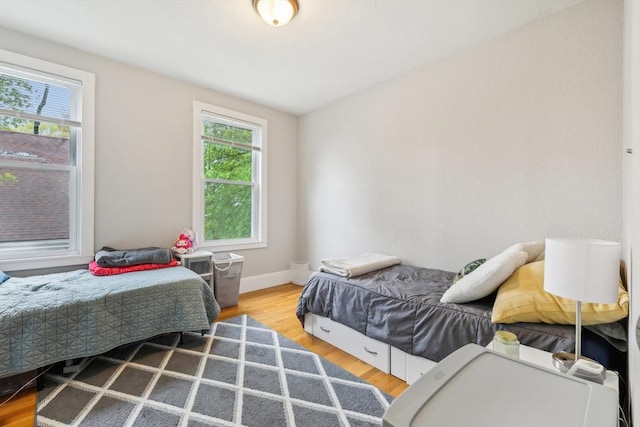 bedroom with baseboards and wood finished floors