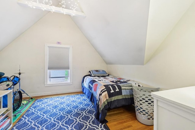 bedroom featuring light wood-type flooring and vaulted ceiling