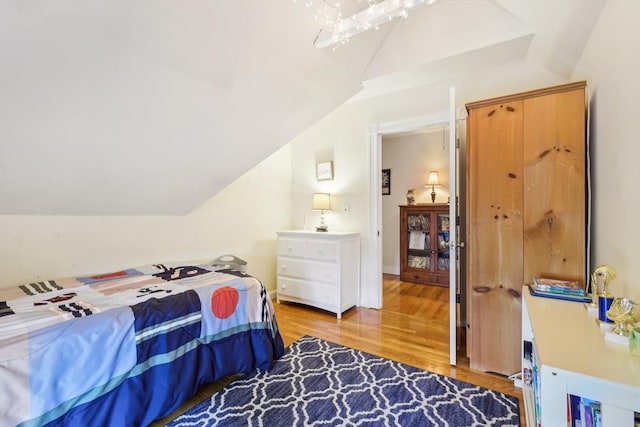 bedroom featuring vaulted ceiling and light wood-type flooring