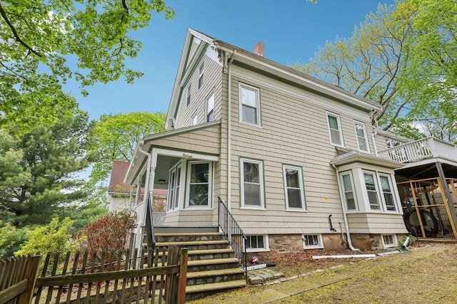 rear view of property with fence and a chimney