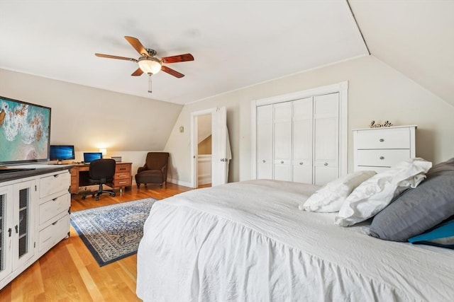 bedroom featuring light wood finished floors, lofted ceiling, a closet, and ceiling fan