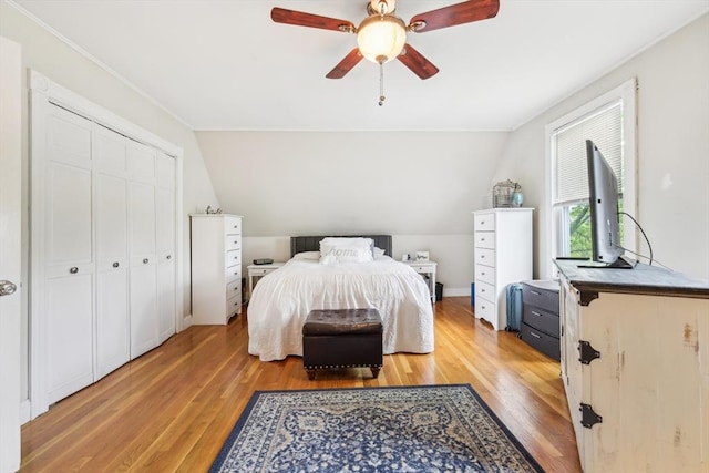 bedroom with light wood finished floors, a closet, a ceiling fan, and lofted ceiling