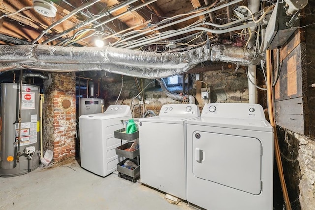 washroom with water heater, washing machine and clothes dryer, and laundry area