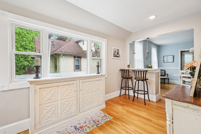 interior space featuring baseboards, light wood finished floors, recessed lighting, and vaulted ceiling