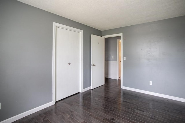 139 Barneyville Rd, Swansea, MA 02777 - unfurnished bedroom featuring dark wood-style floors, baseboards, a textured ceiling, and a closet
