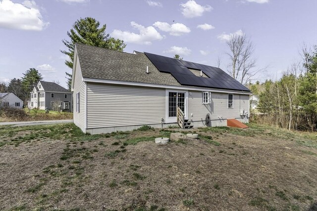 1 Lois Ln, Townsend, MA 01469 - back of house featuring a shingled roof, roof mounted solar panels, and entry steps