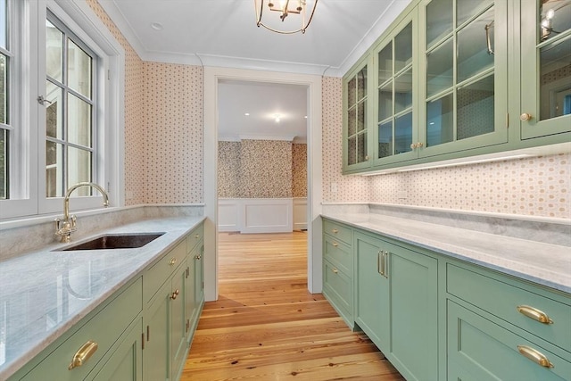 kitchen featuring a sink, green cabinets, and wallpapered walls
