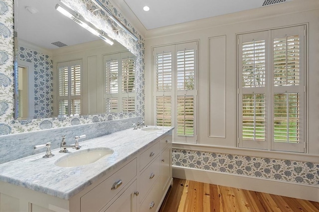 full bathroom with a healthy amount of sunlight, a sink, and wood finished floors