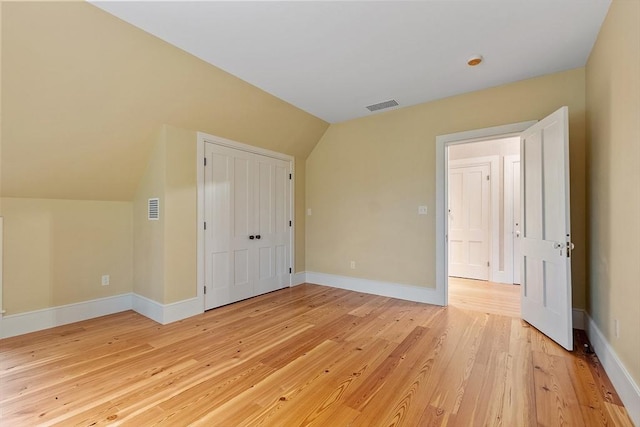 bonus room with visible vents, baseboards, lofted ceiling, and light wood-type flooring