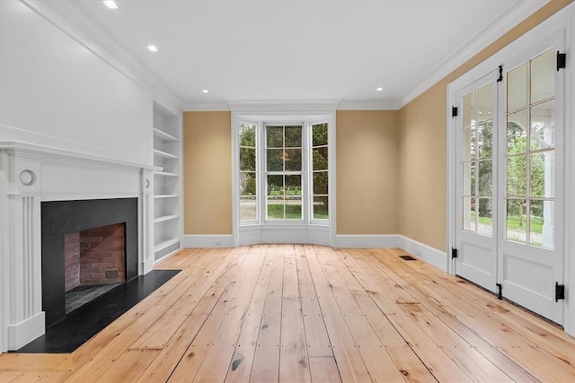 unfurnished living room with crown molding, built in features, plenty of natural light, and wood-type flooring