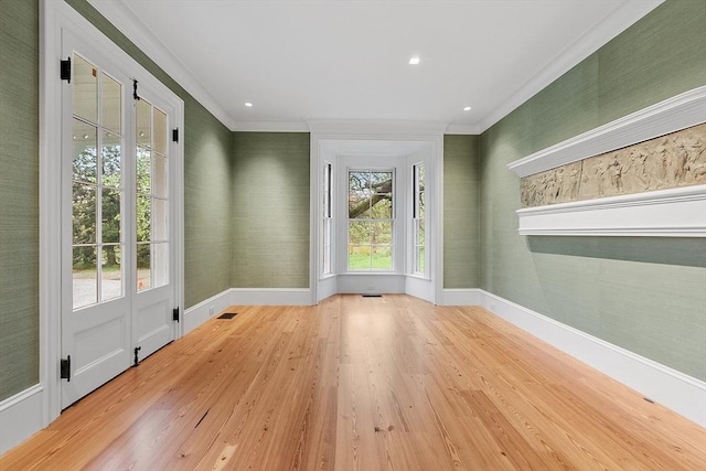doorway to outside featuring crown molding, baseboards, visible vents, and wood finished floors