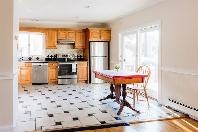 kitchen with stainless steel appliances, baseboard heating, tasteful backsplash, and ornamental molding