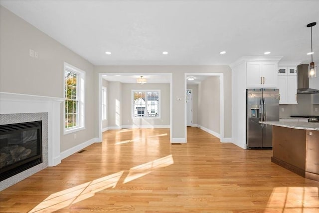 70 Princeton St, Holden, MA 01522 - kitchen with recessed lighting, white cabinetry, stainless steel fridge with ice dispenser, wall chimney exhaust hood, and light wood-type flooring