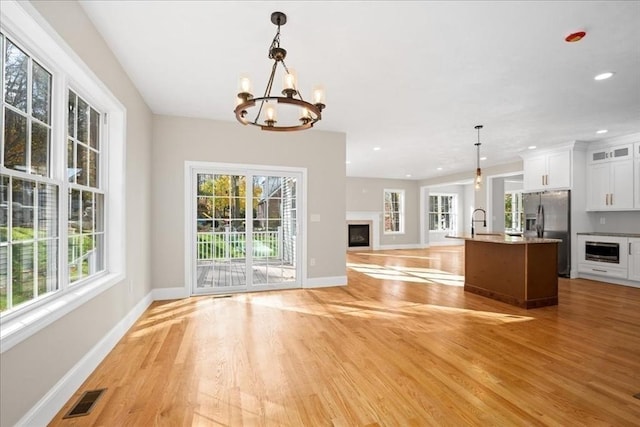 70 Princeton St, Holden, MA 01522 - kitchen featuring visible vents, an inviting chandelier, light wood-style flooring, open floor plan, and stainless steel fridge with ice dispenser