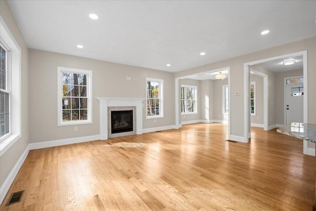 70 Princeton St, Holden, MA 01522 - unfurnished living room with baseboards, a wealth of natural light, light wood-style flooring, and visible vents