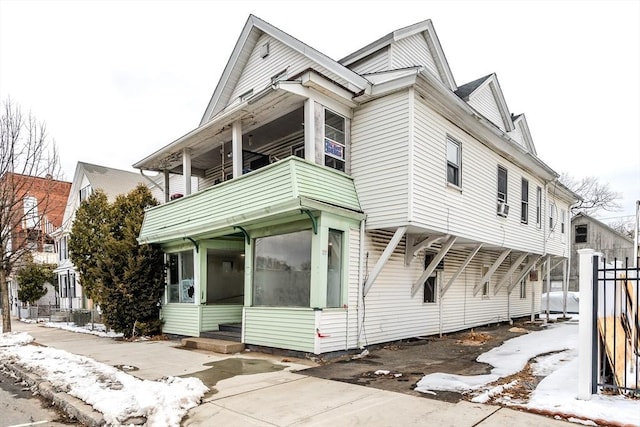 view of front of property featuring entry steps, a sunroom, and a balcony