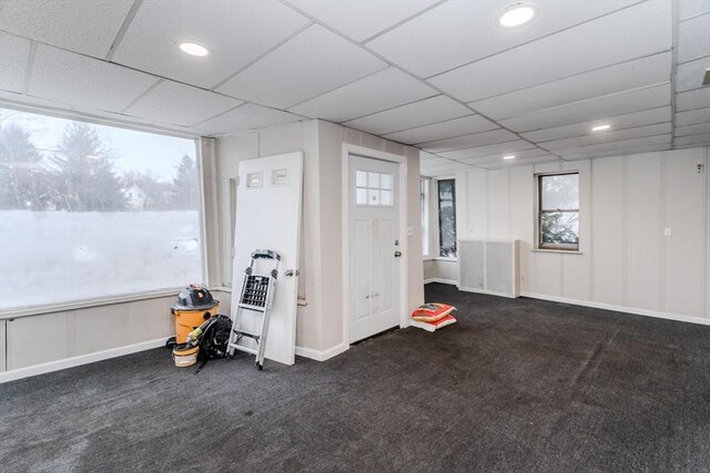 below grade area featuring carpet flooring, a paneled ceiling, and baseboards