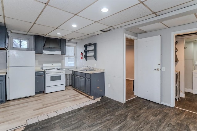 kitchen featuring gray cabinets, light countertops, light wood-style floors, a sink, and white appliances