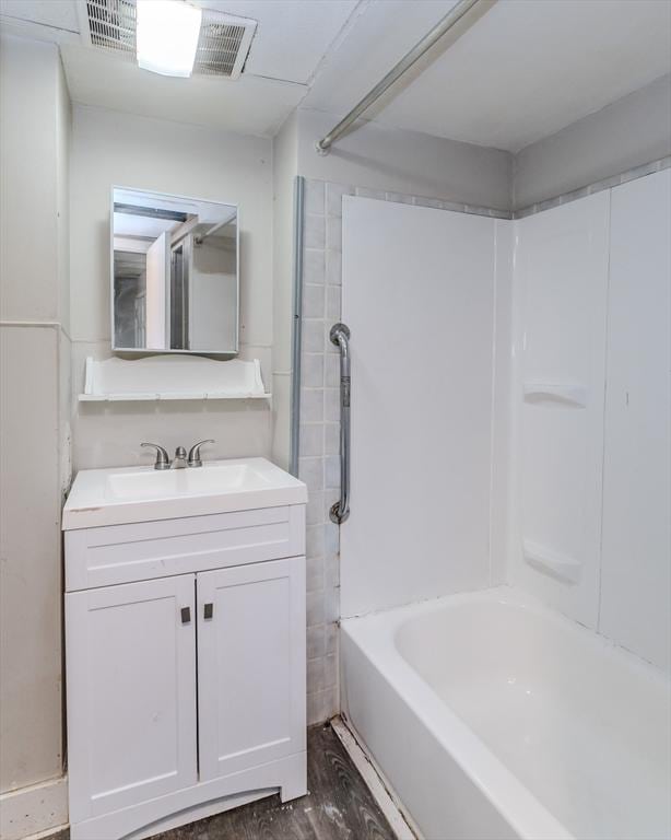 bathroom featuring visible vents,  shower combination, wood finished floors, and vanity