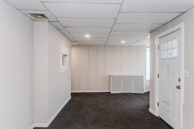 finished basement with a paneled ceiling, baseboards, visible vents, and carpet flooring