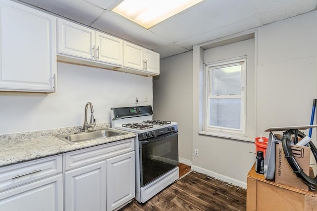 kitchen featuring range with gas stovetop, white cabinets, dark wood-type flooring, and a sink