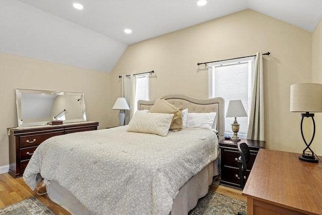 bedroom with vaulted ceiling and light hardwood / wood-style flooring