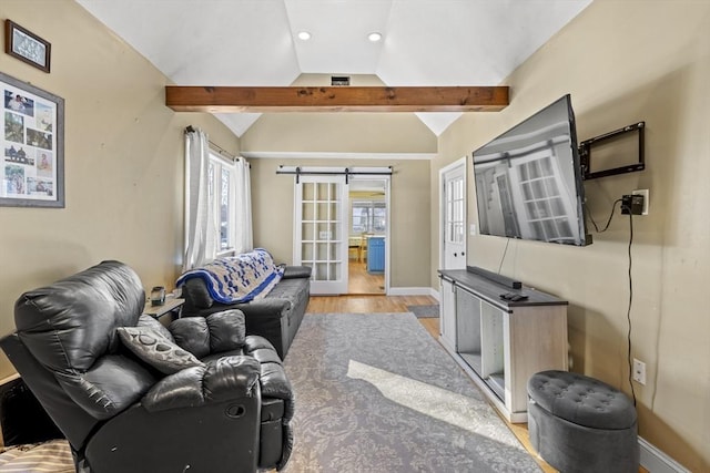 living room with a barn door, light wood-type flooring, and vaulted ceiling with beams