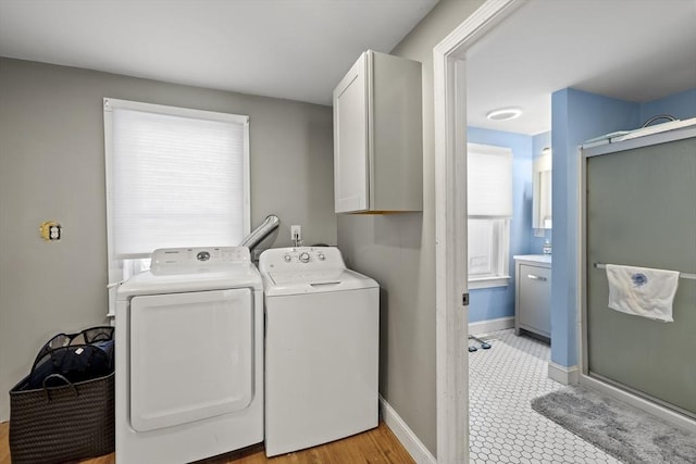 washroom featuring cabinets and washer and clothes dryer