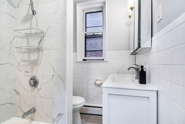 full bathroom with toilet, vanity, a baseboard heating unit, tile walls, and tub / shower combination